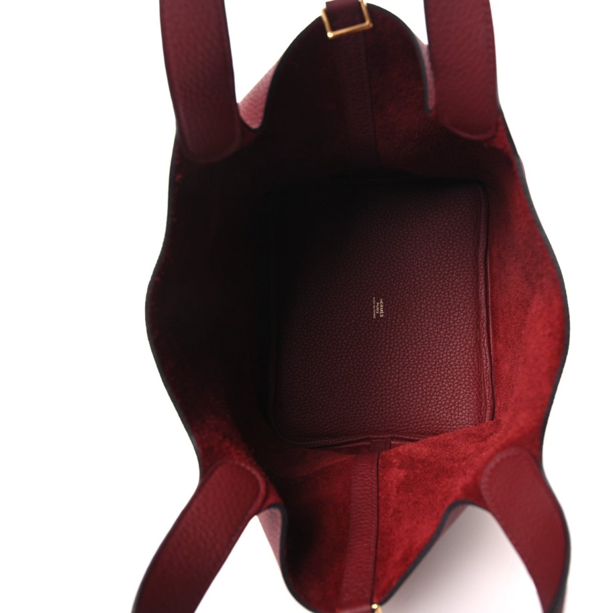 Red leather tote bag interior with pocket lining and gold-tone lock clasp.