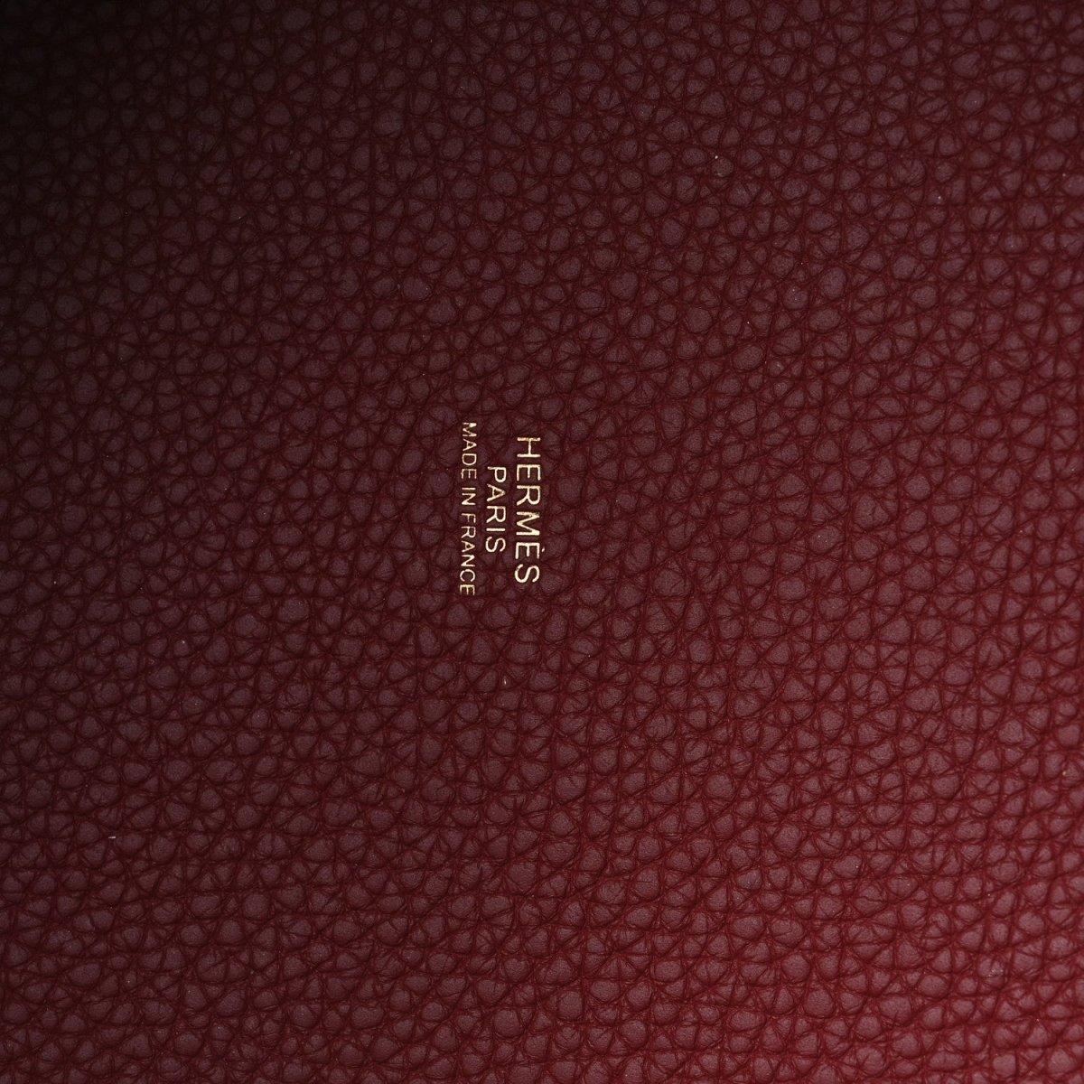 Red pebbled leather with embossed maker name visible on inner panel.