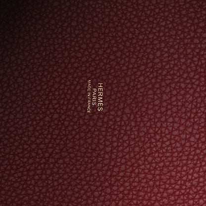 Red pebbled leather with embossed maker name visible on inner panel.