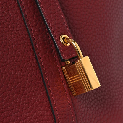 Small red leather tote with gold lock clasp and shoulder strap