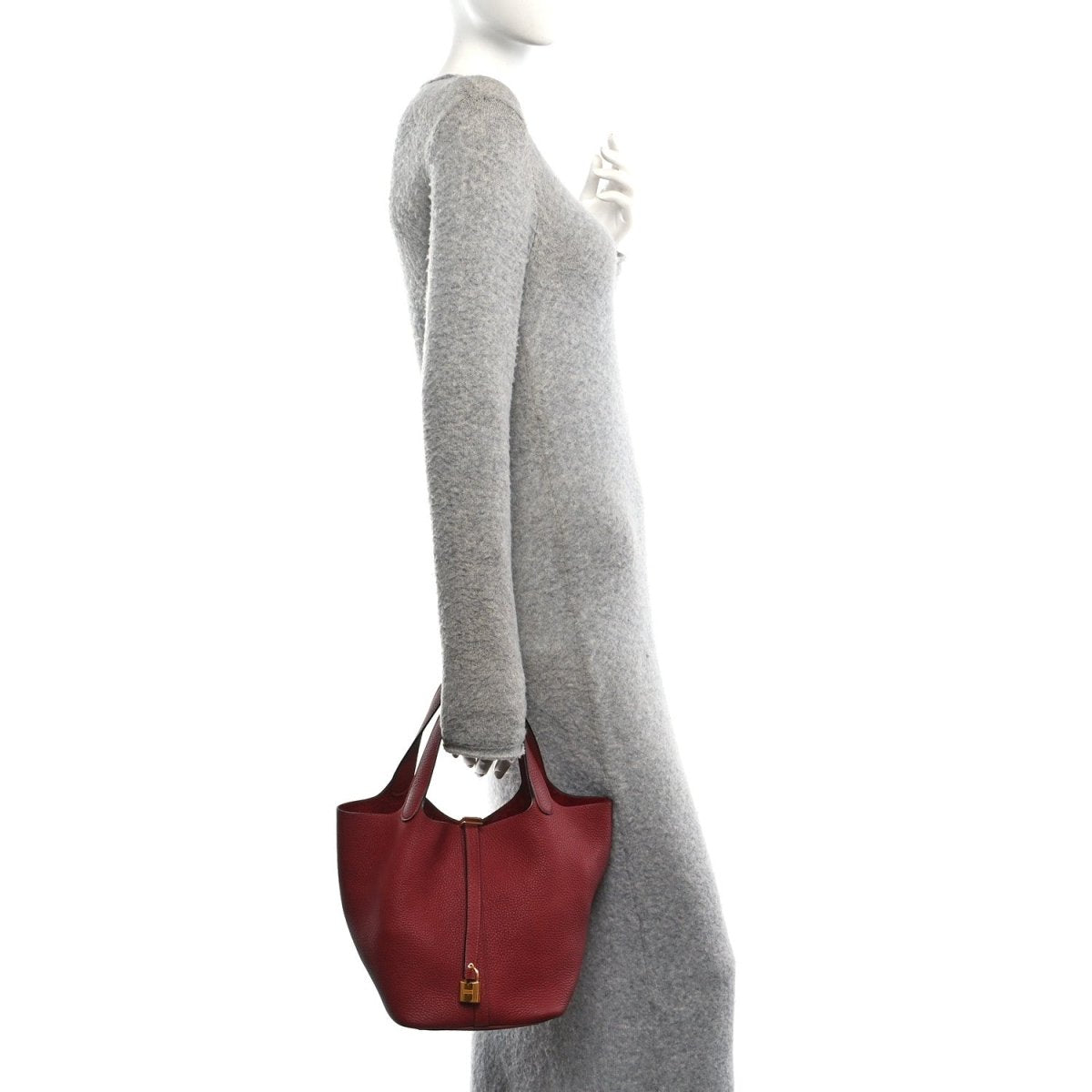 Red leather tote bag worn on shoulder, top handles and lock with gold hardware.