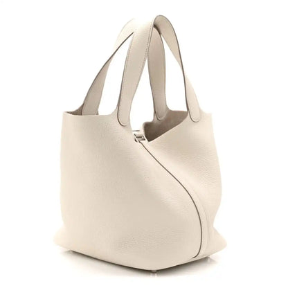 Off-white leather bucket bag from back/side with curved silhouette and handles