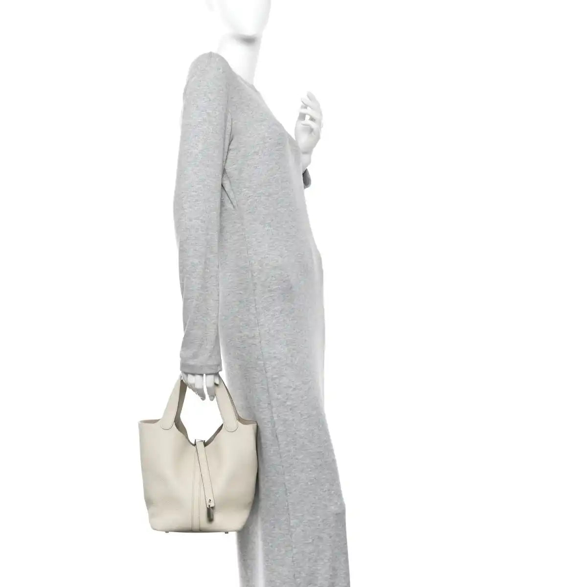 Off-white leather bucket bag carried by model with two top handles