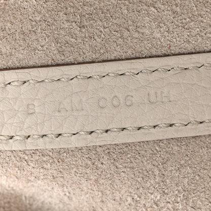 Off-white leather bucket bag seam with embossed maker marks and stitched edge