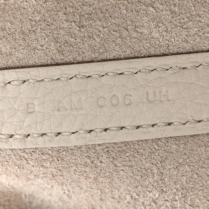 Off-white leather bucket bag seam with embossed maker marks and stitched edge
