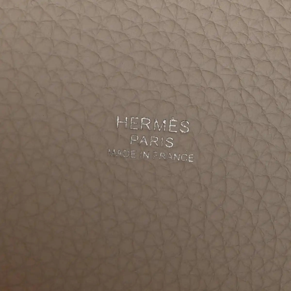 Off-white leather bag base with embossed brand text HERMES PARIS