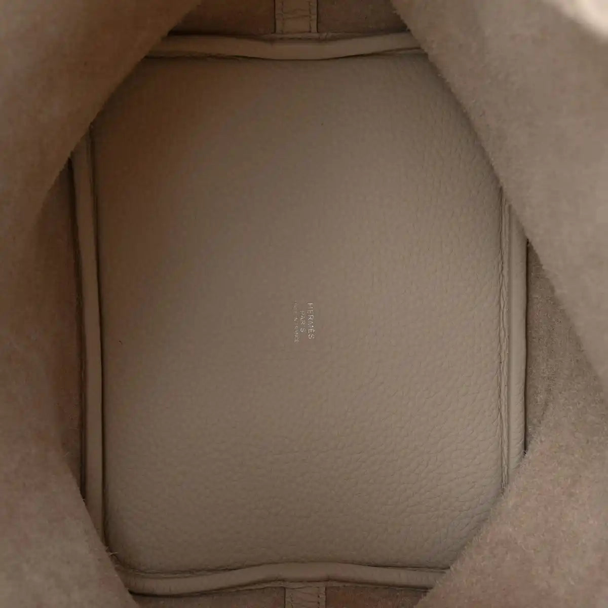 Off-white leather bucket bag interior with smooth lining and molded side walls