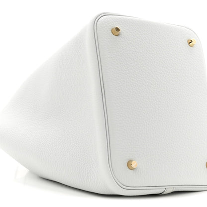 Light blue leather bucket tote with two gold-toned snap buttons and rounded shape