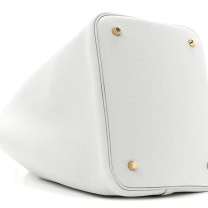 Light blue leather bucket tote with two gold-toned snap buttons and rounded shape