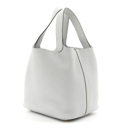Light blue pebbled leather bucket tote with curved top handles and side seam