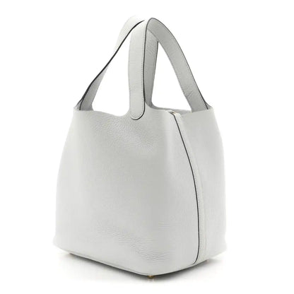 Light blue pebbled leather bucket tote with curved top handles and side seam