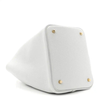 Light blue leather bucket tote corner with snap buttons and curved edge