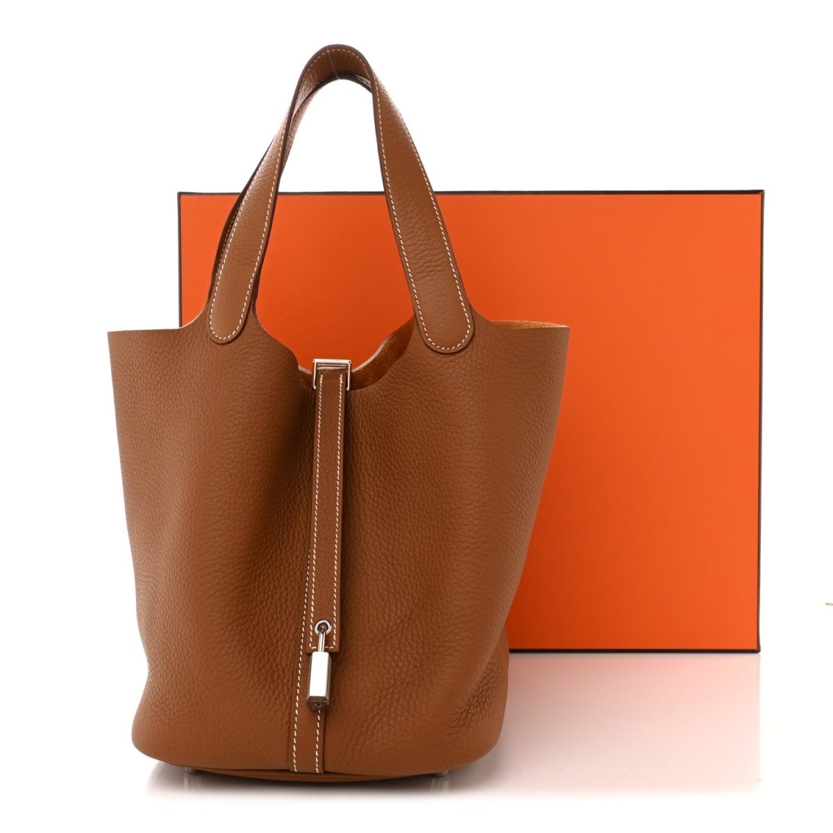 Brown leather tote bag with two top handles and vertical lock closure