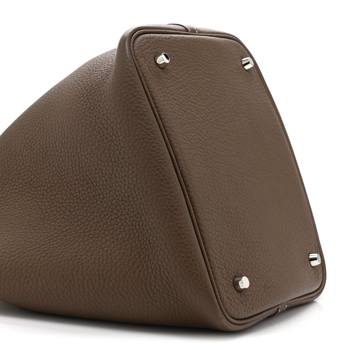 Taupe leather tote bag with top handle and metal stud closure on side panel