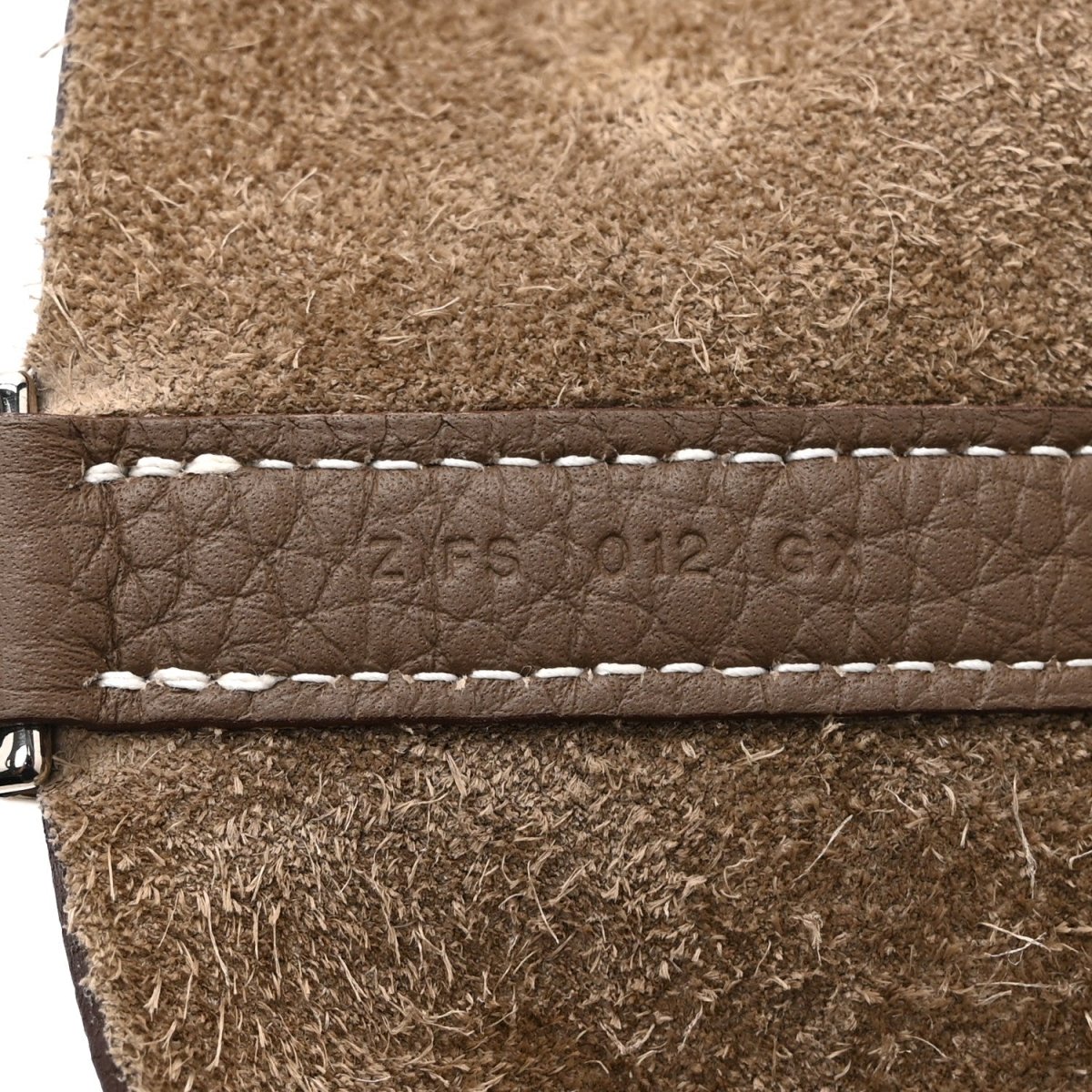 Taupe leather tote bag edge with contrast stitching and embossed brand marks