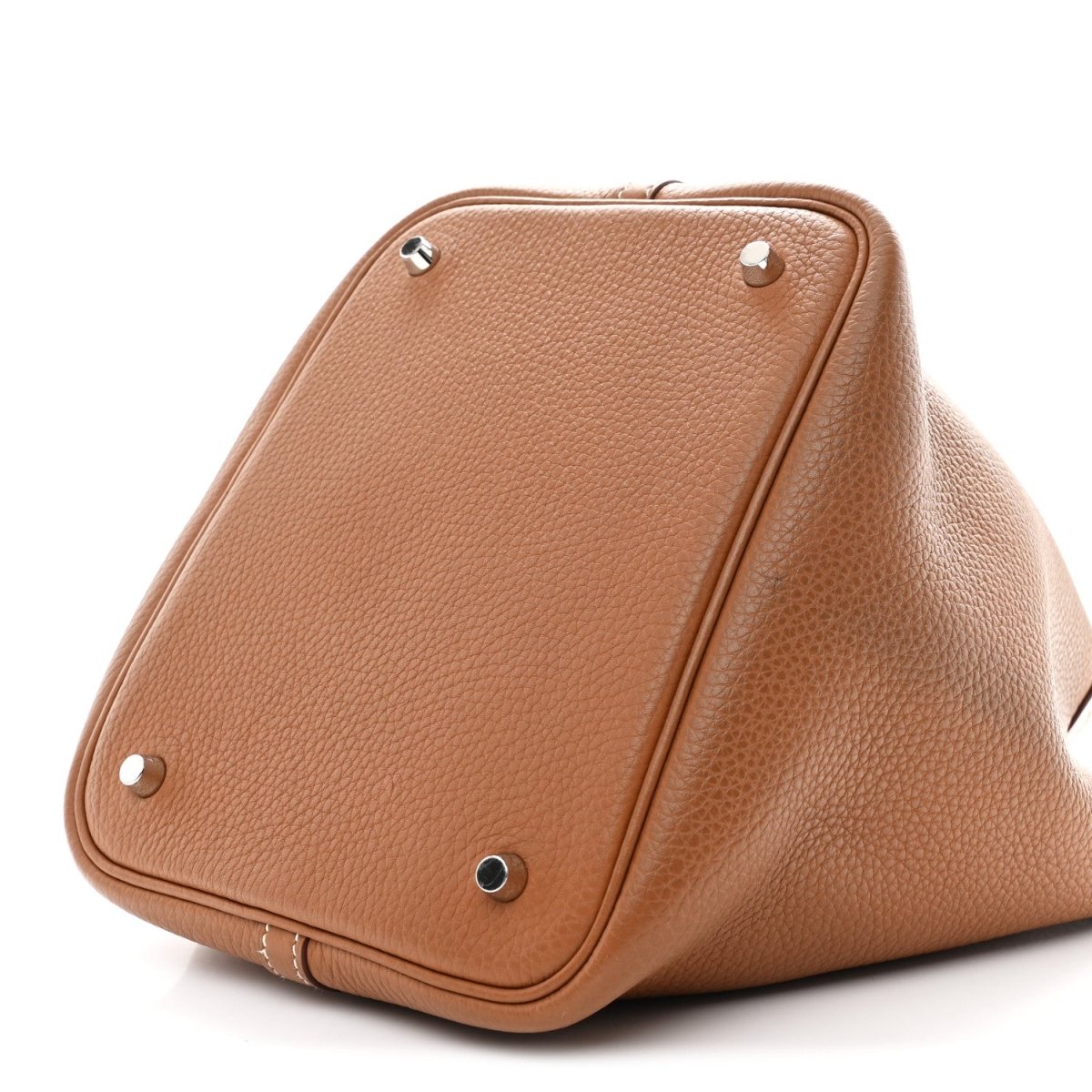 Tan leather tote bag with top handle loops and metal corner feet