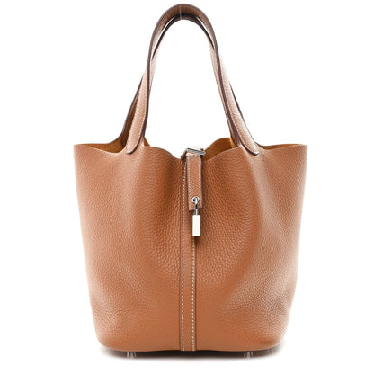 Tan leather tote bag with top handles and front lock zipper pull