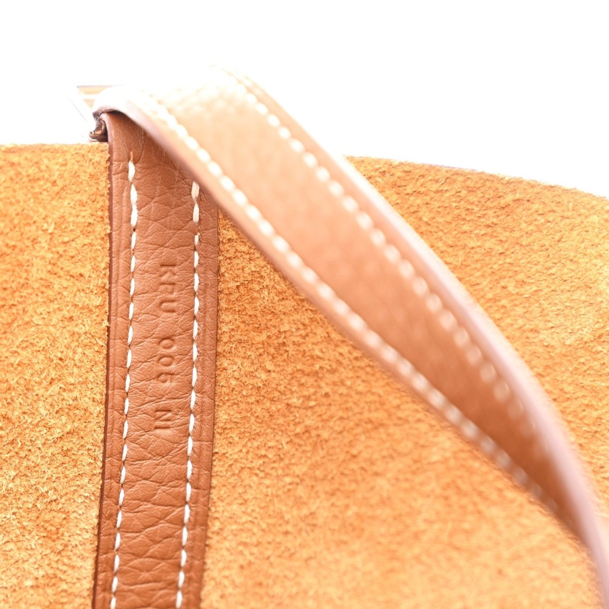 Tan leather strap end with contrast white stitching