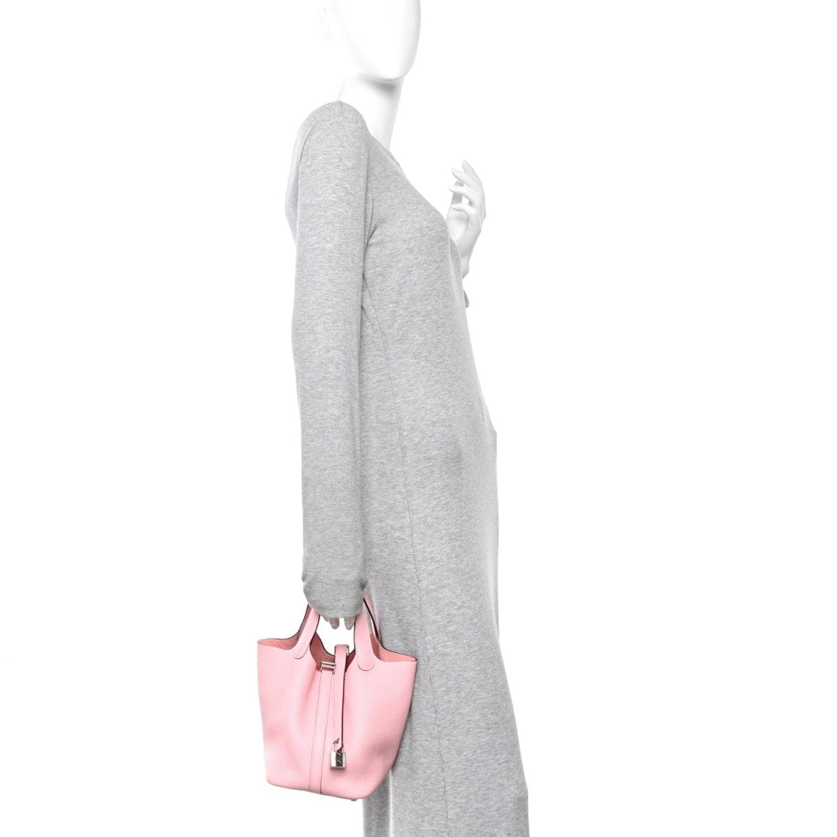 Rose pink leather mini bucket bag with top handles, shown being carried at side
