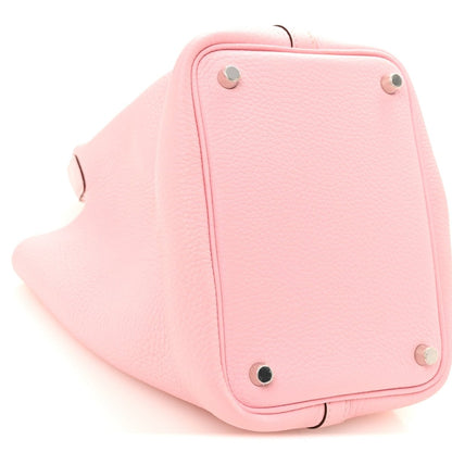 Rose pink leather bucket bag corner with metal studs and curved base