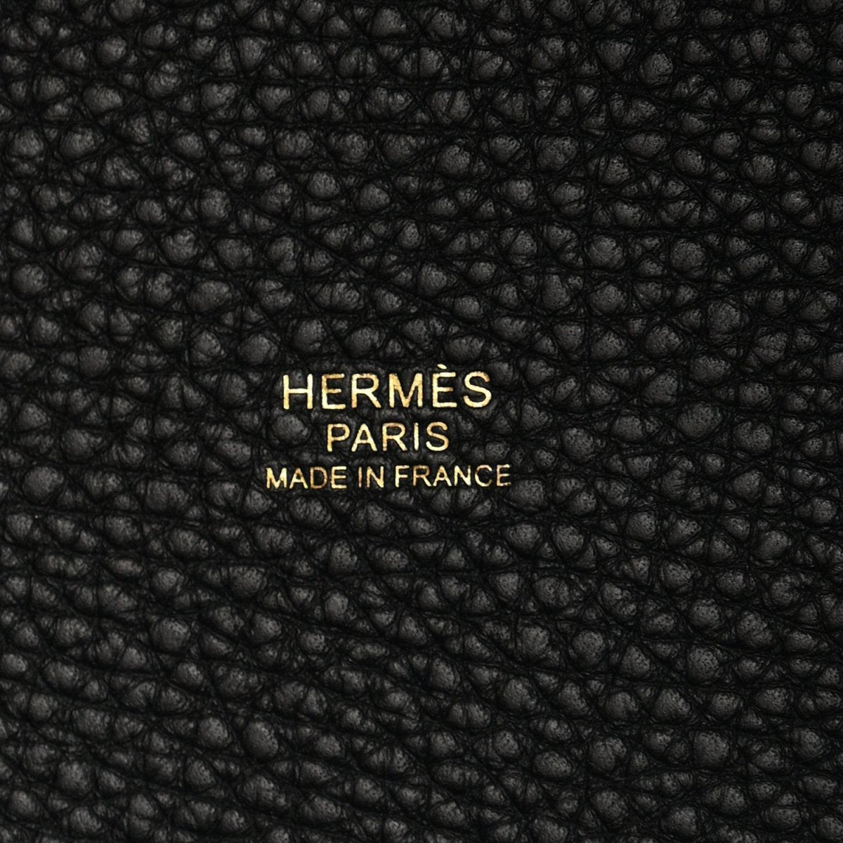 Black leather tote panel with embossed “HERMES PARIS MADE IN FRANCE” text.
