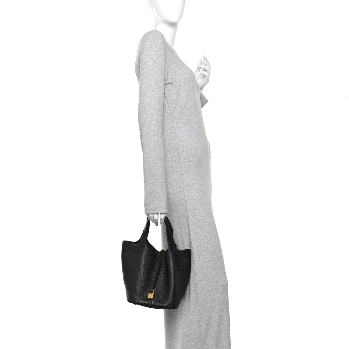 Black leather tote bag worn on shoulder with gold-tone lock at center.