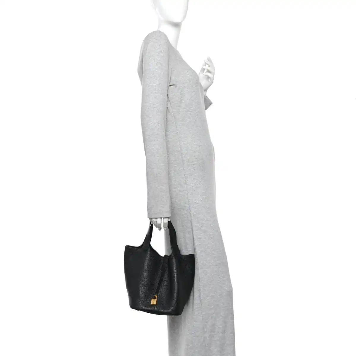Black leather tote bag worn on shoulder with gold-tone lock at center.