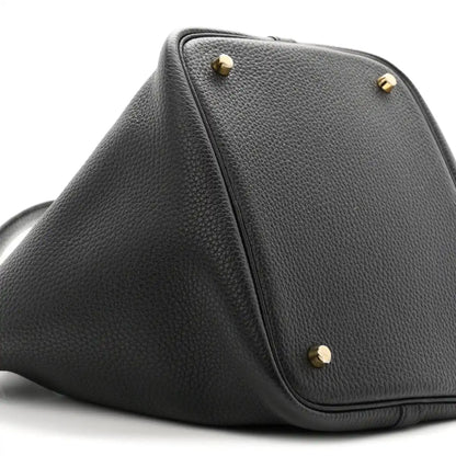 Black leather top-view of tote with gold-tone studs and front corner stitching.