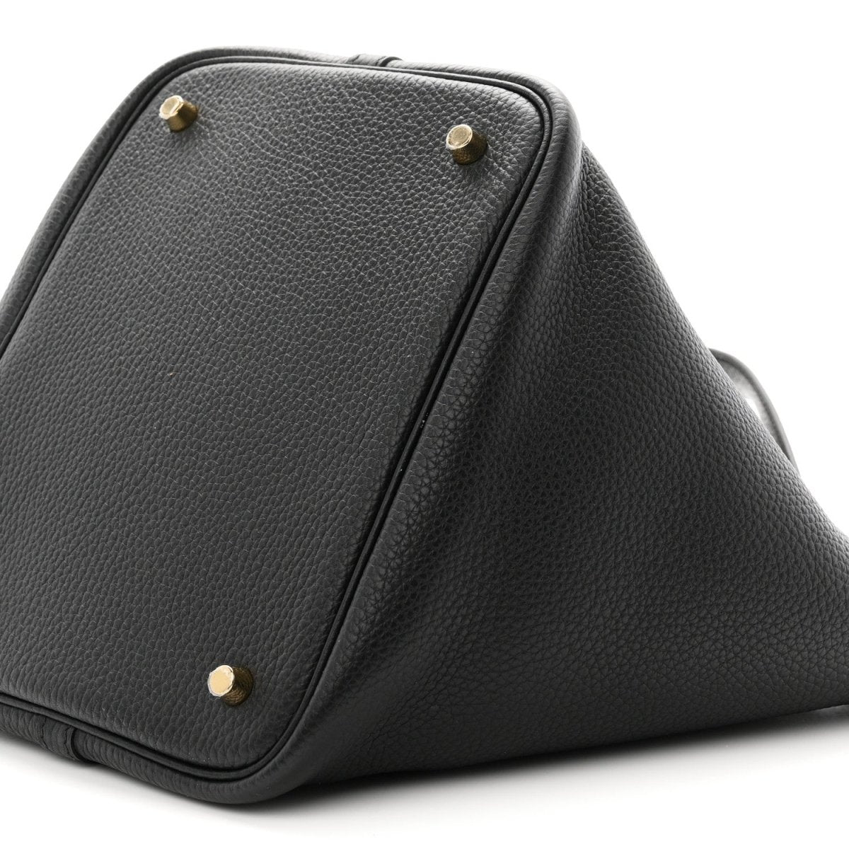 Black leather tote corner with gold-tone studs and angled top panel seam.