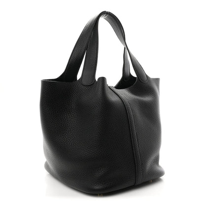 Black leather shoulder tote with curved body and structured bottom.