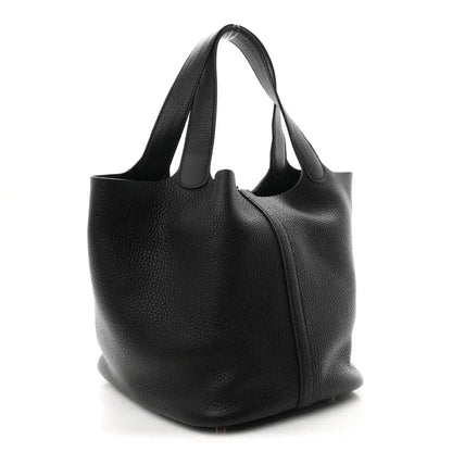 Black leather shoulder tote with curved body and structured bottom.