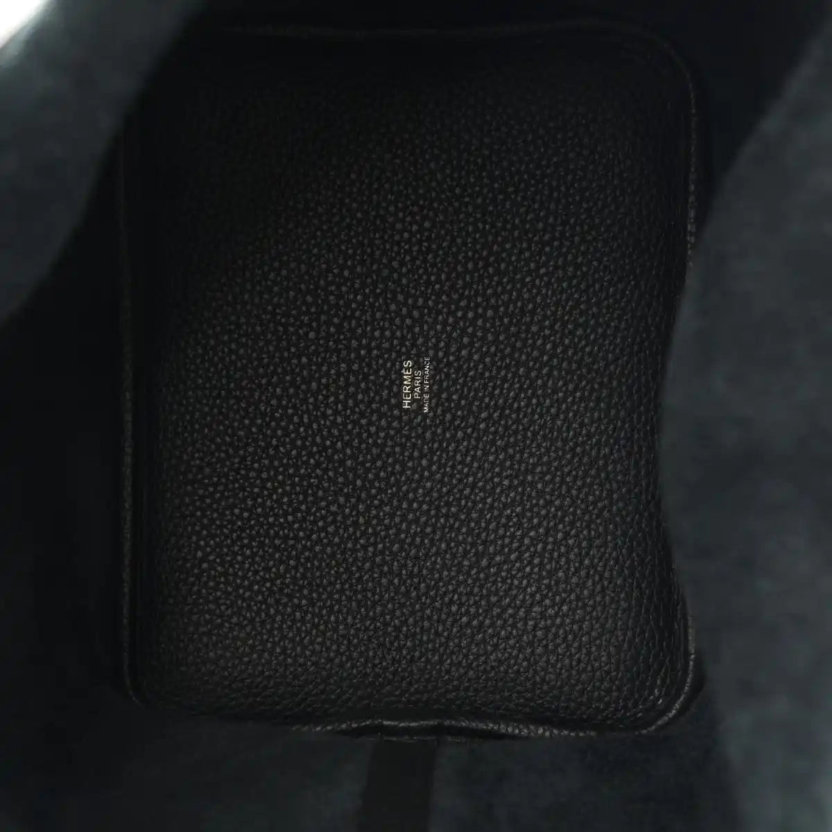 Black leather tote, textured grain with central stamped branding.