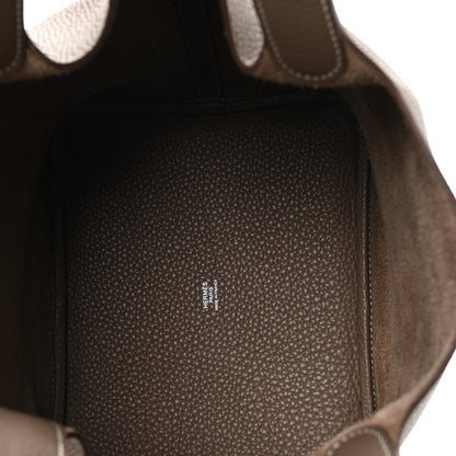Taupe leather handbag interior view with Hermes stamp on lining pocket