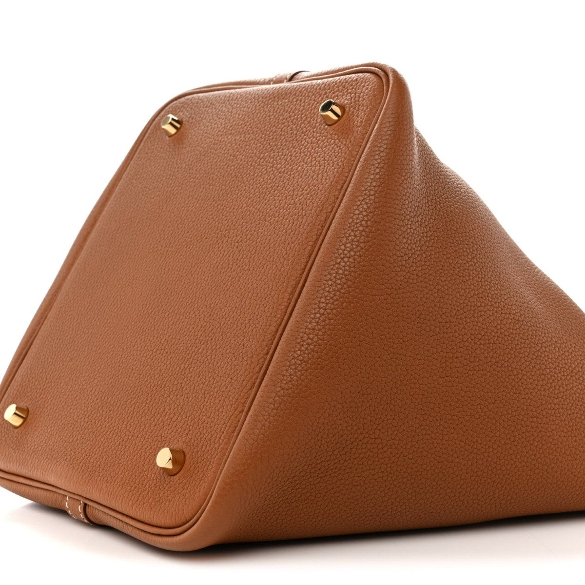 Tan leather tote bag with gold corner studs and folded side panel seam