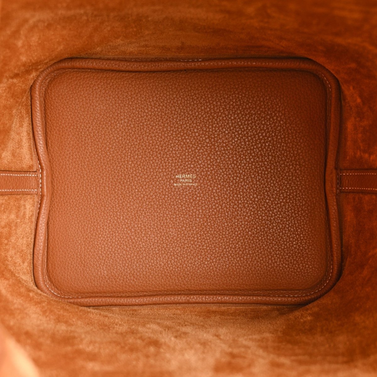 Tan leather interior pocket with stitched edges and small Hermes branding