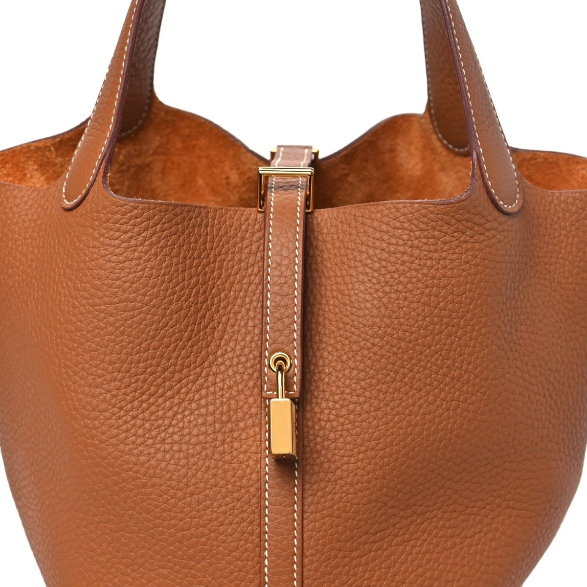 Leather tote front with gold lock hardware and top handles, tan/brown textured grain.