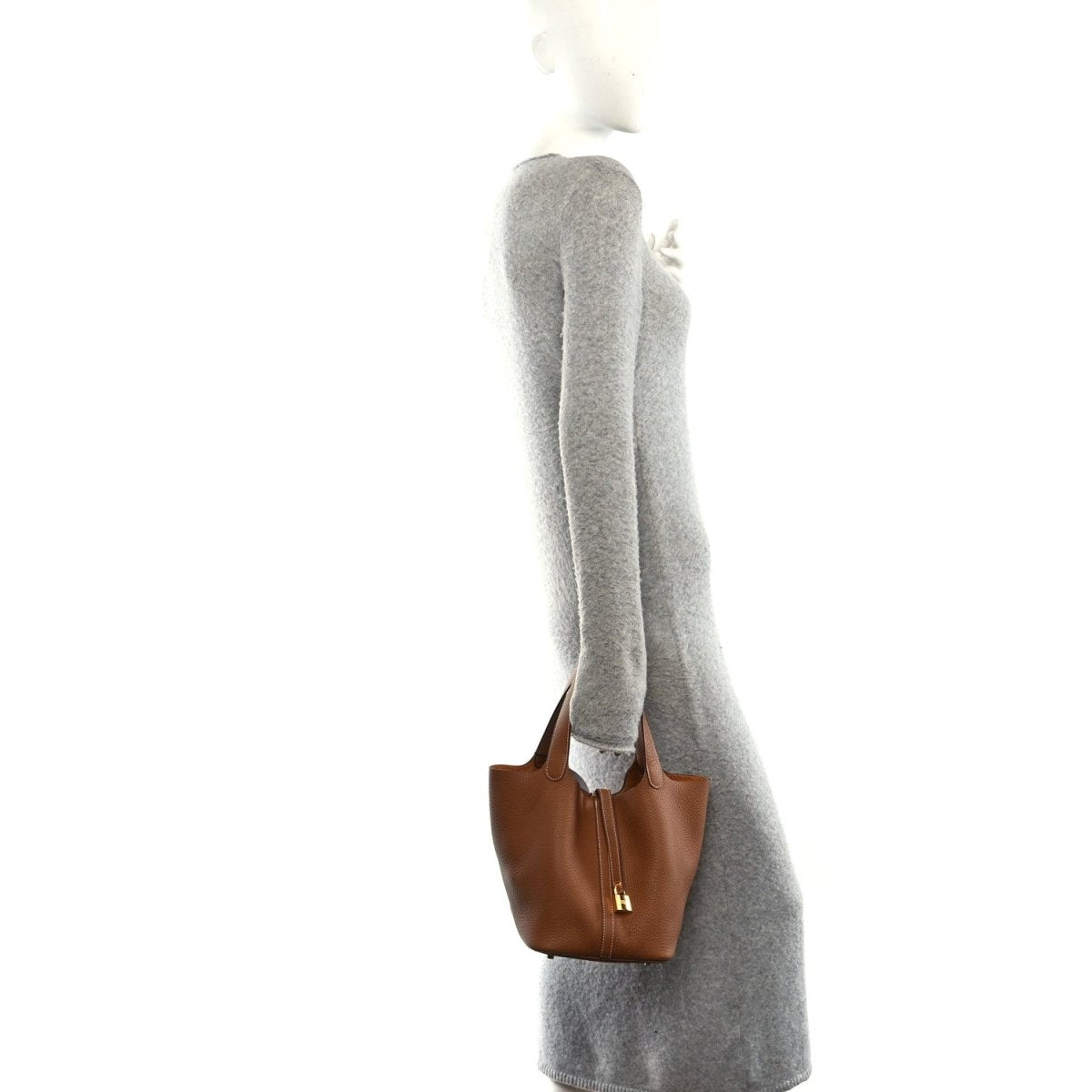 Leather tote bag on a sleeve, tan/brown with gold H charm.