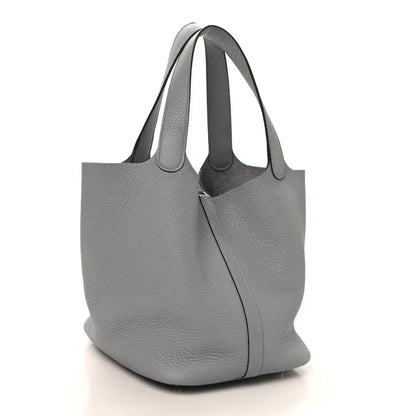 Grey leather tote bag with an adjustable strap and gold clasp lock