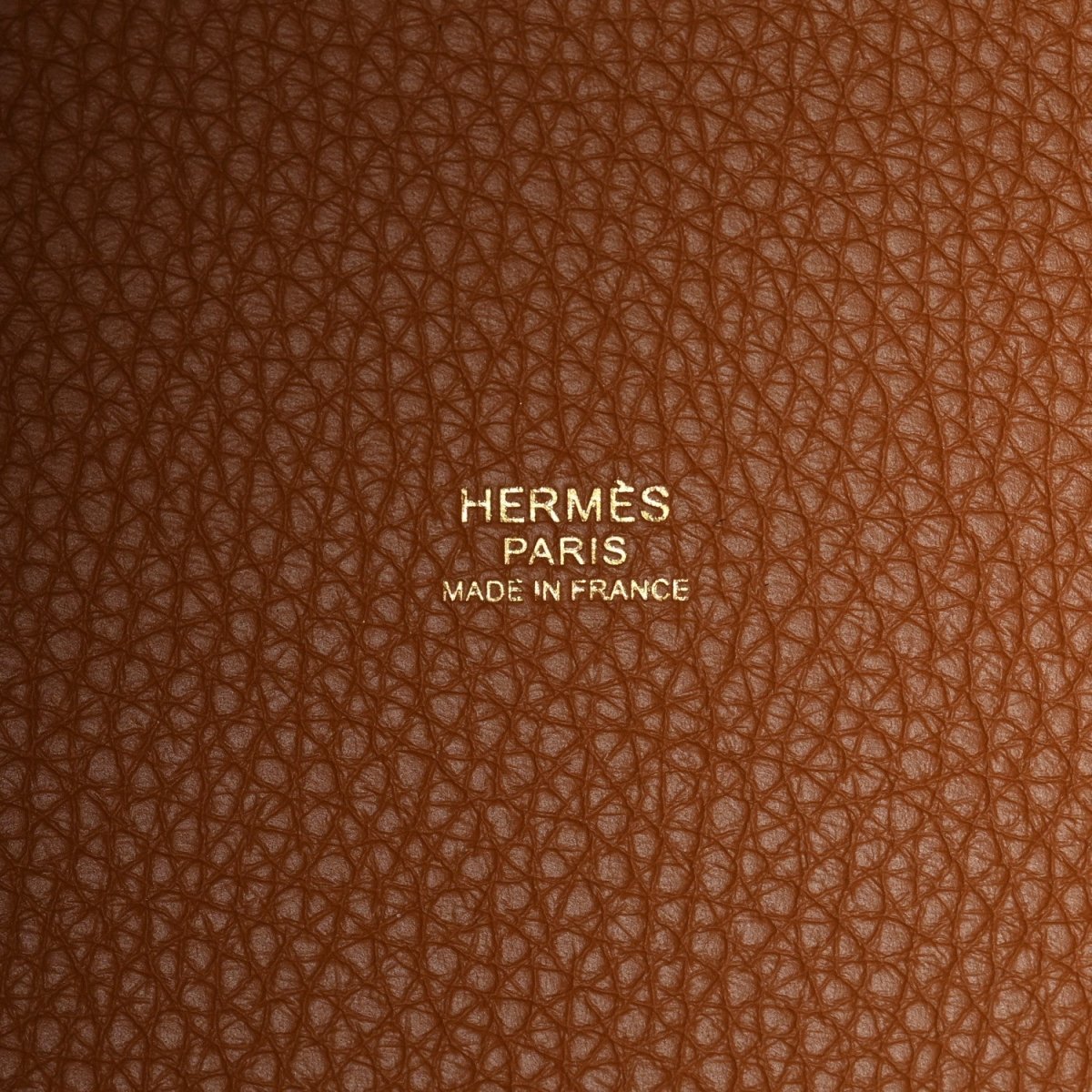 Hermès Paris leather stamp on orange-tan grain