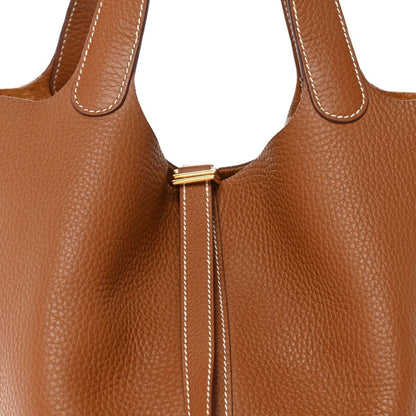 Tan leather bucket bag top with gold-tone lock and double drawstring ties