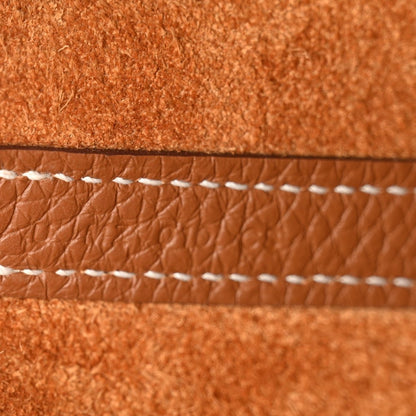 Tan leather bucket bag with white stitched trim and textured grain