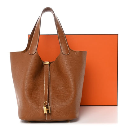 Leather bucket bag with gold lock and tan handles