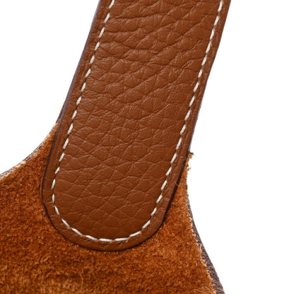 Leather bucket bag strap close-up with stitched seam and smooth brown grain