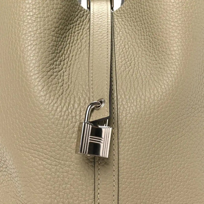 Sauge leather handbag with silver lock clasp on front seam
