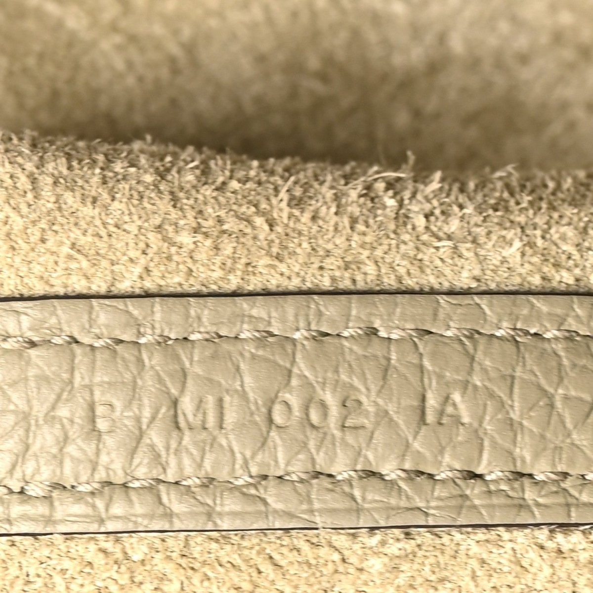 Leather edge with embossed lettering and visible stitching