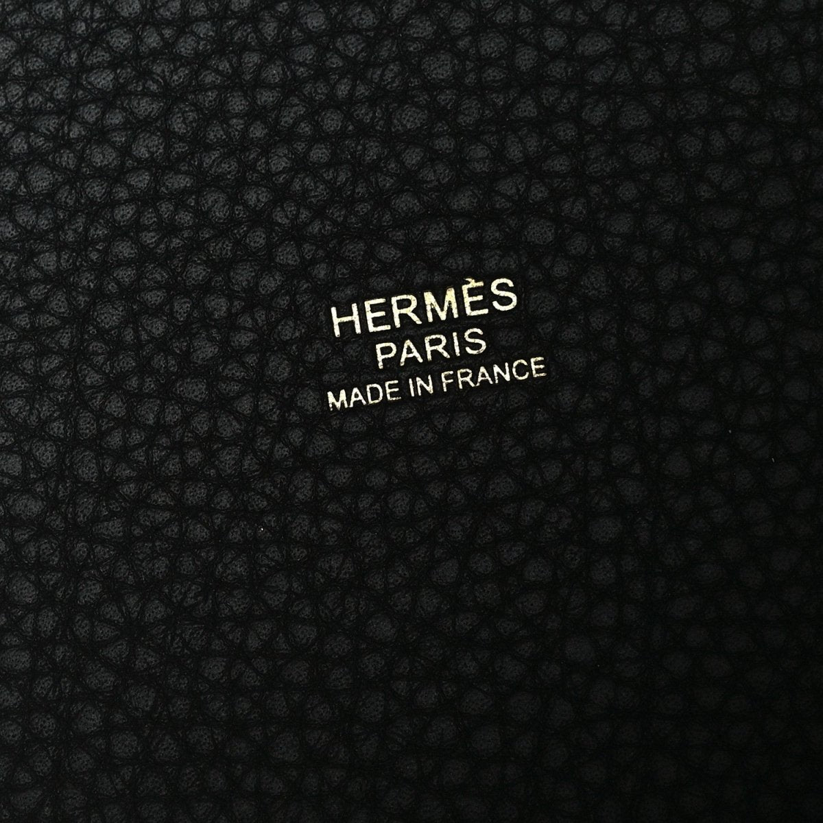 Black leather with embossed “HERMÈS PARIS” and “MADE IN FRANCE” text.