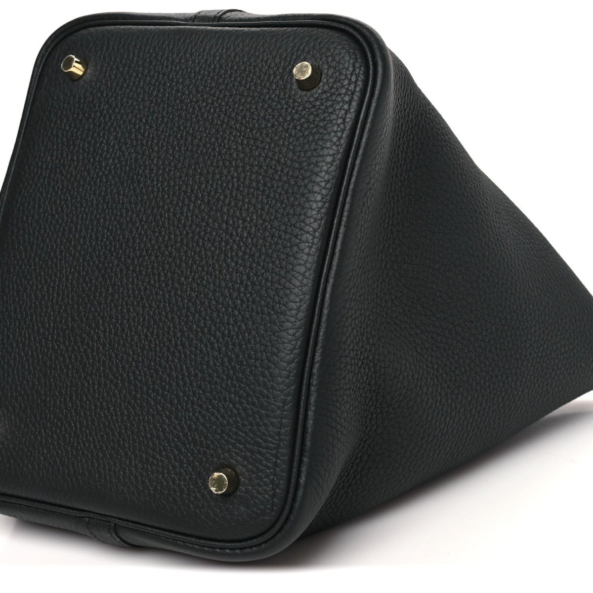Black leather tote bag corner view with gold-tone rivets and curved side panels.