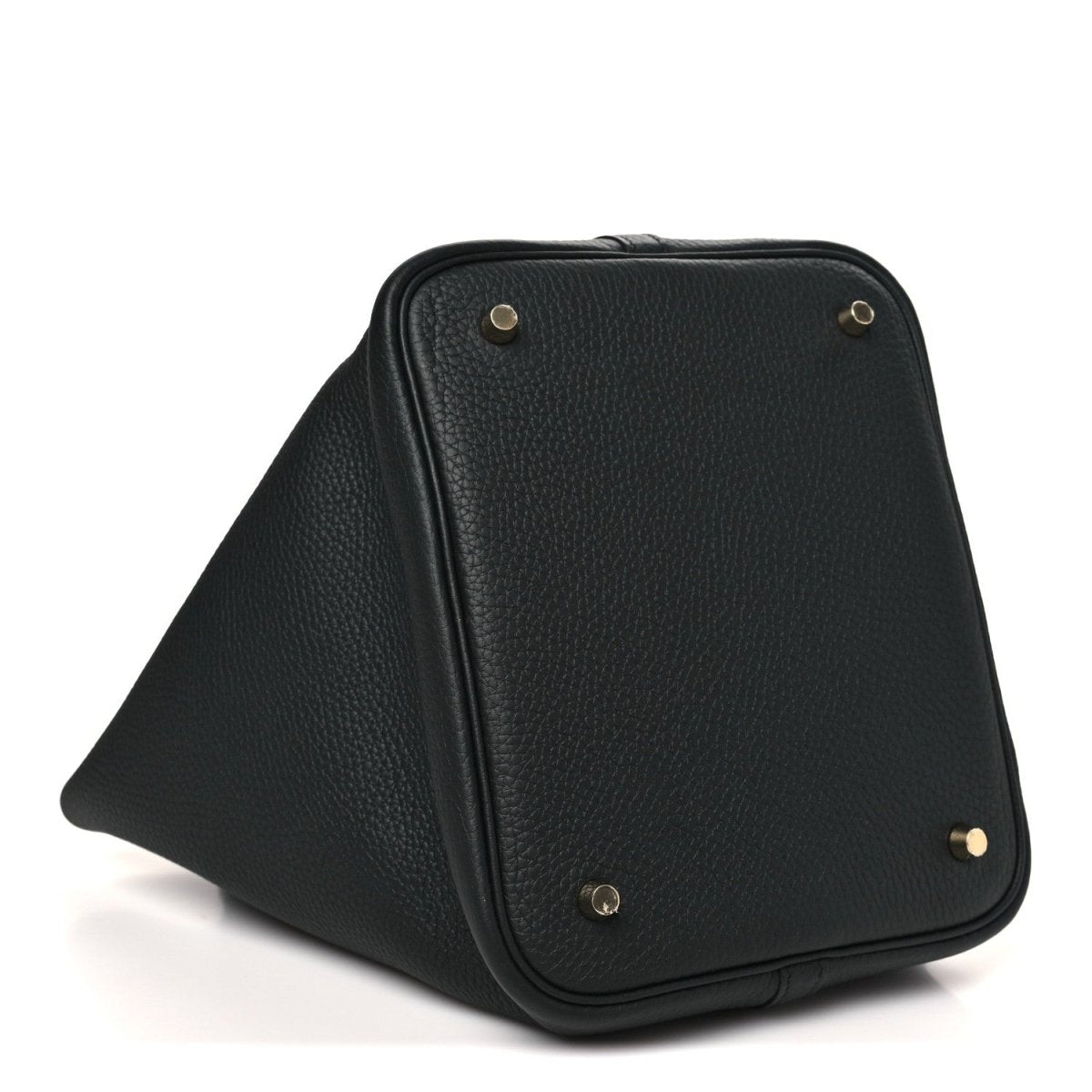 Black leather tote bag with gold-tone corner hardware and top flap seam detail.
