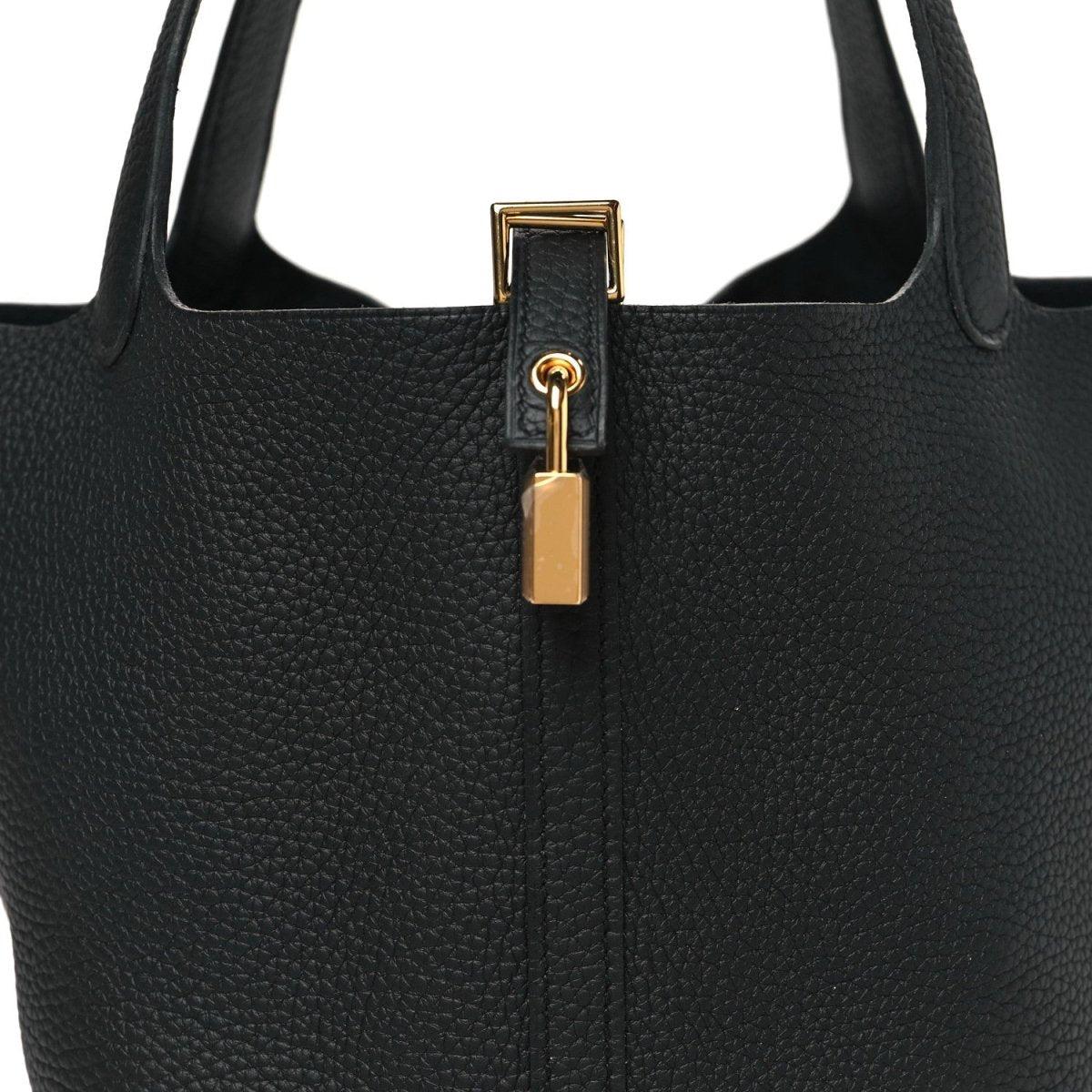 Close-up of black leather tote top with gold-tone lock and ring clasp hardware.