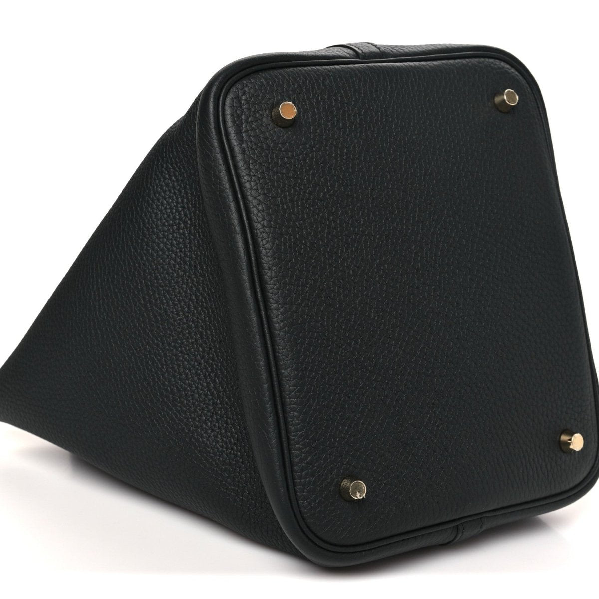 Black leather tote bag angled view with textured surface and gold-tone top hardware.
